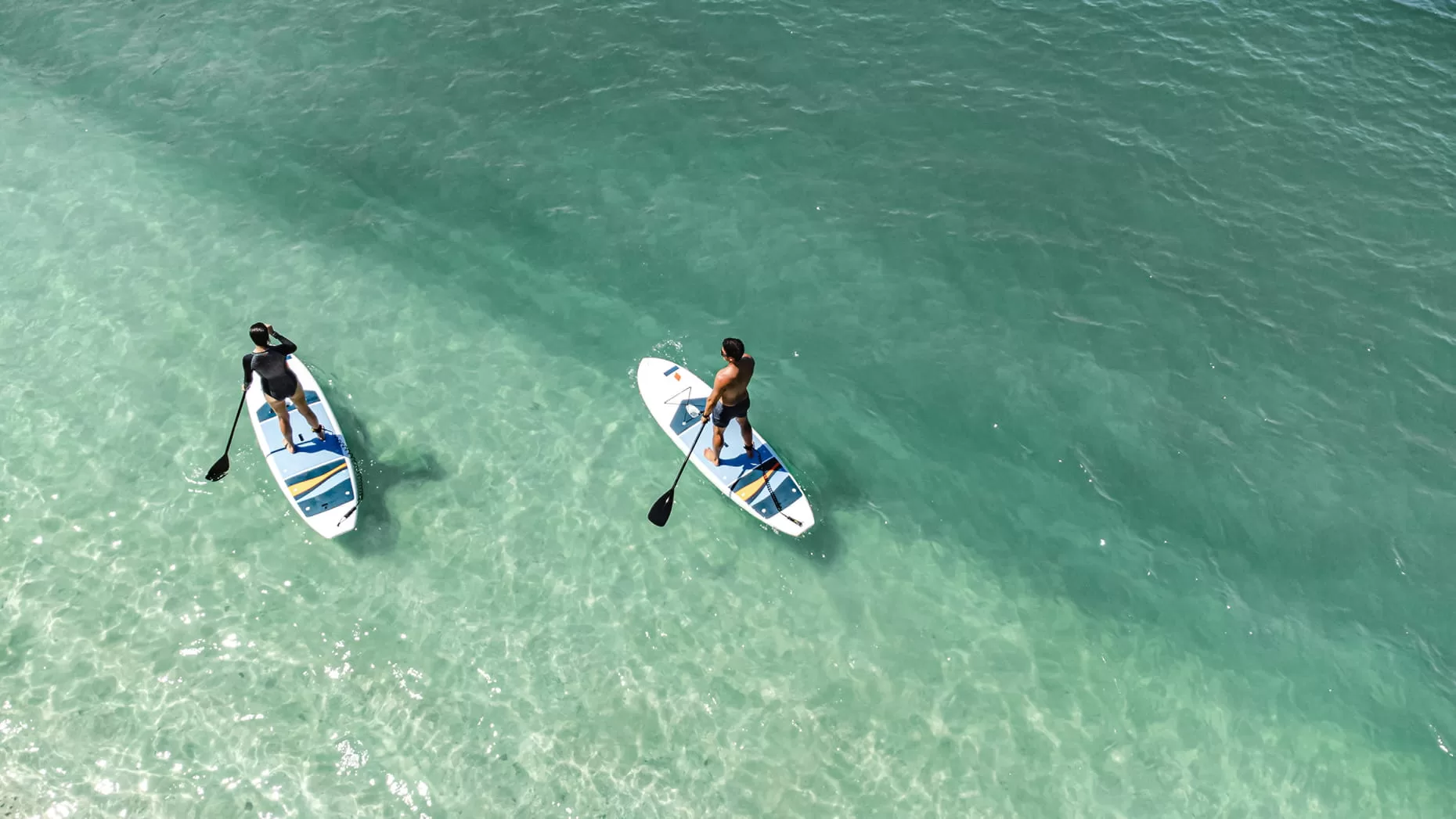 Kayaks and stand-up paddleboards on calm morning water in Flamingo Bay, Costa Rica